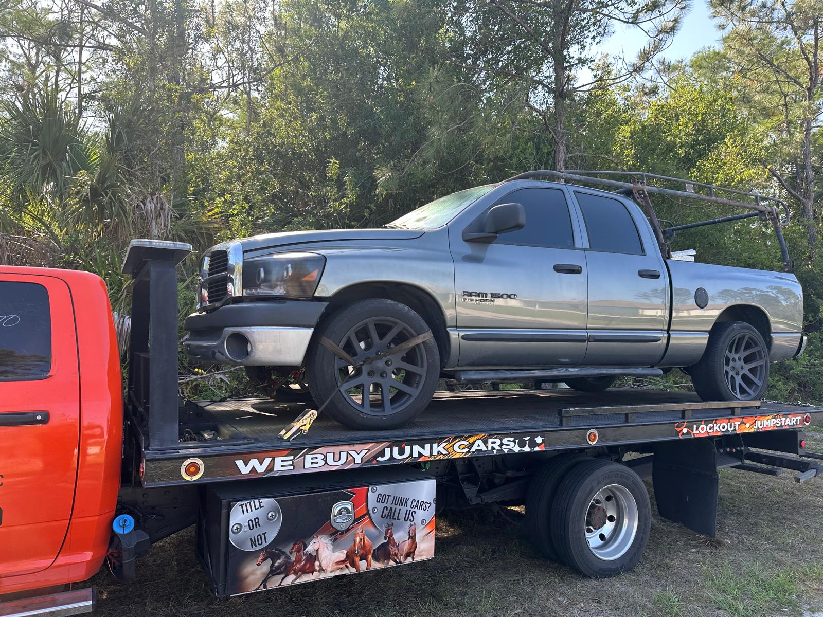 A car being towed on a San Roman Towing Services flatbed truck